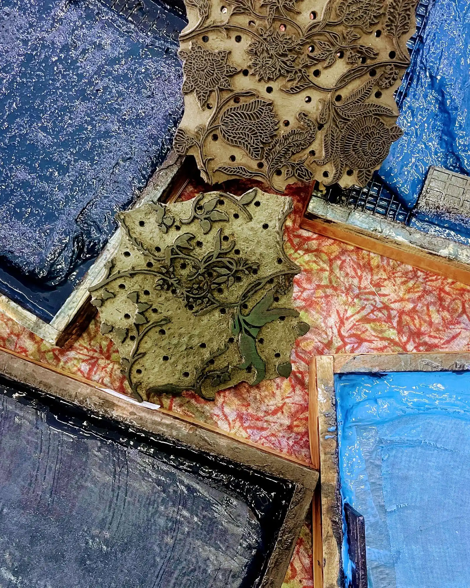 Floral printing blocks beside blue colour trays